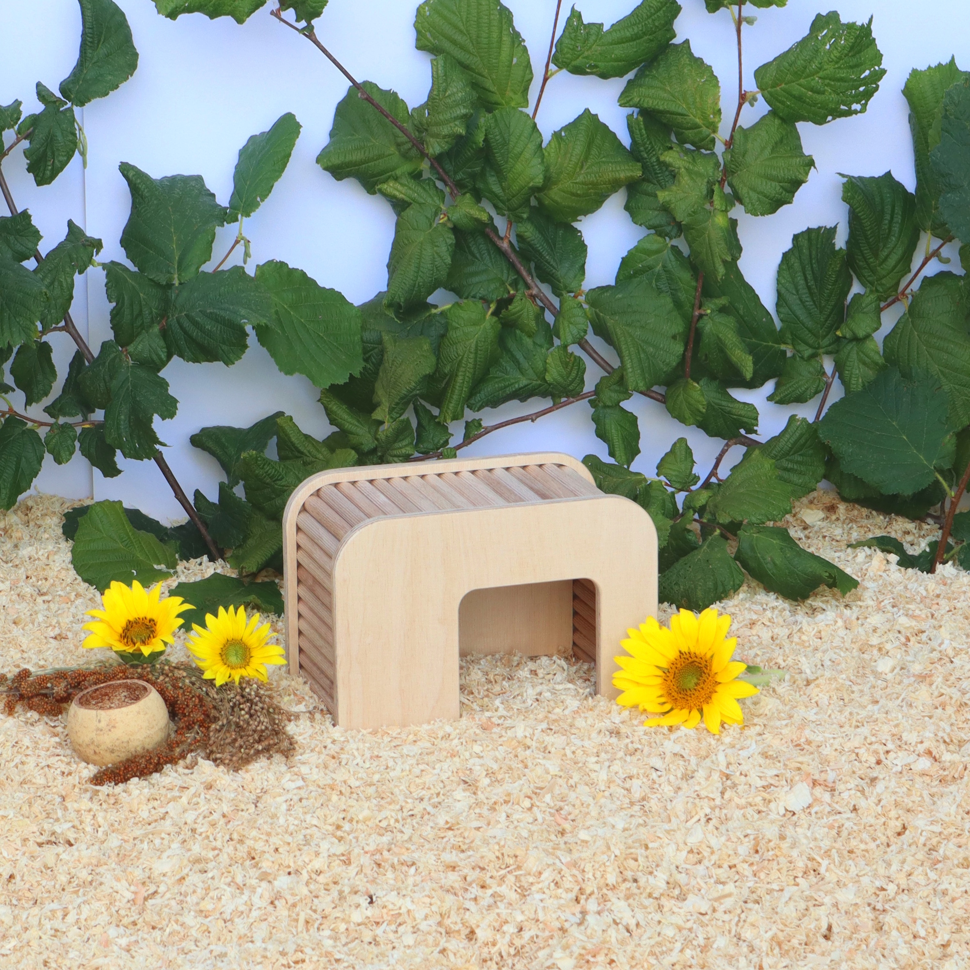 Das Foto zeigt ein Hamsterversteck aus Holz im Hamstergehege